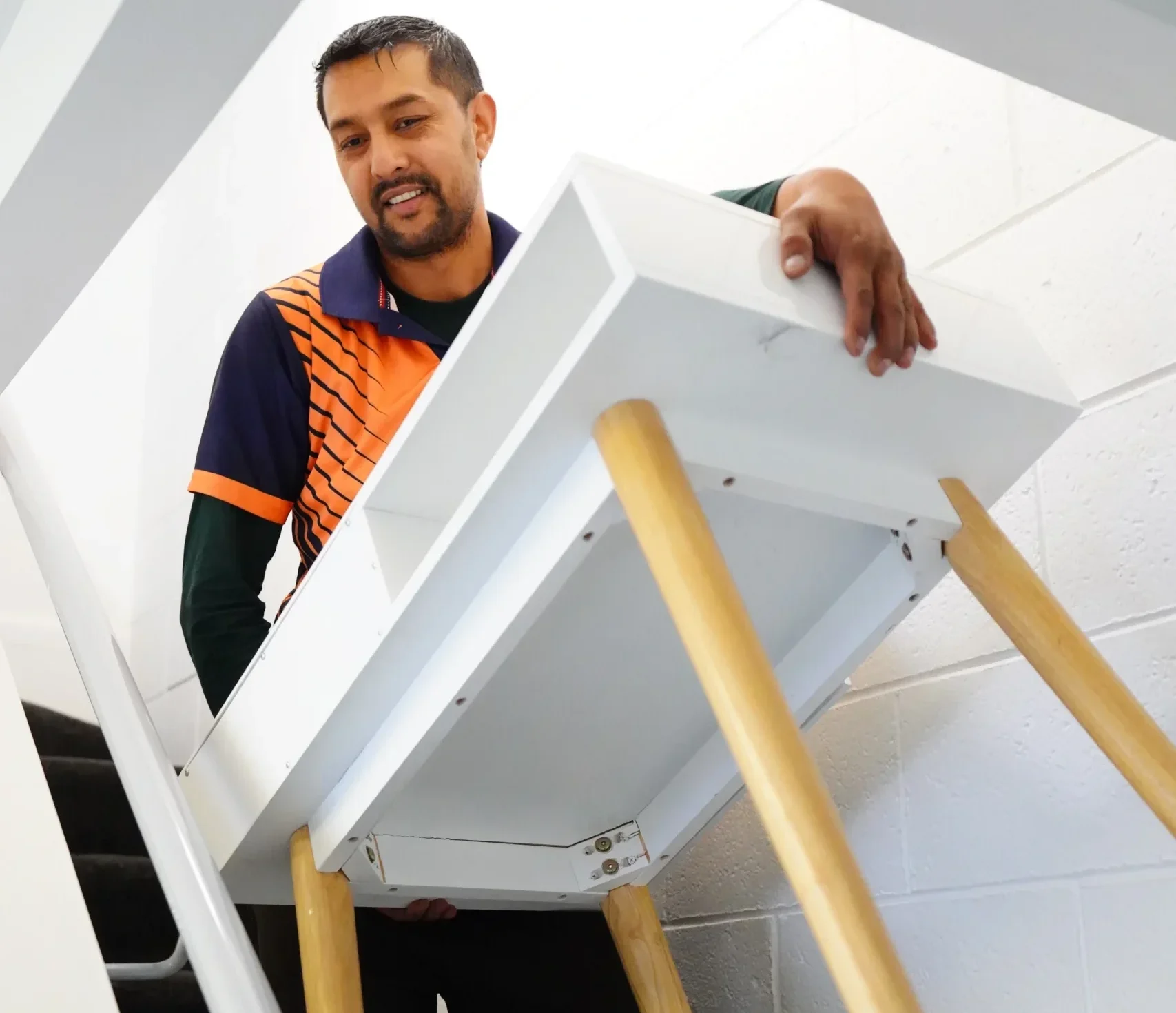 Furniture movers in Christchurch carefully carrying a table during a safe furniture moving service